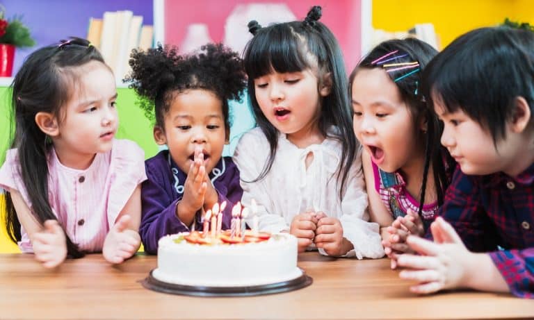 Un groupe d'enfants souffle les bougies sur un gâteau d'anniversaire inoubliable.