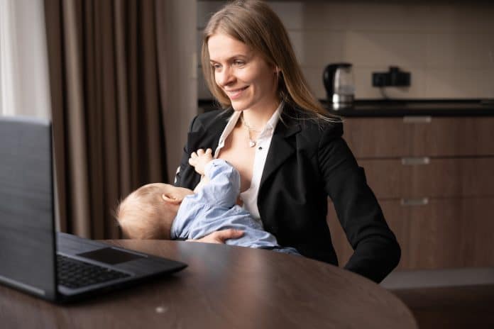 Une femme allaite son bébé sur son lieu de travail.