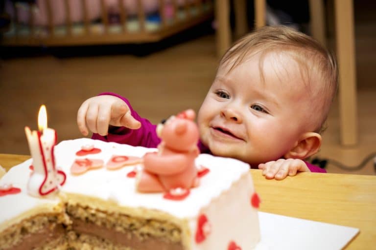 Un bébé regarde un gâteau d'anniversaire pour son premier anniversaire.