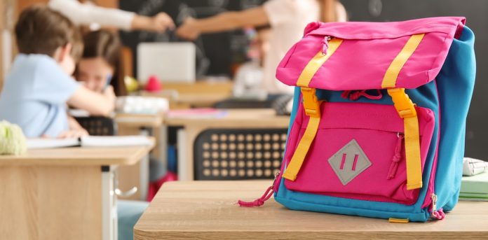 un chariot coloré est placé sur un bureau au premier plan ; des élèves et un enseignant sont flous à l'arrière plan de la classe, capturant l'essence de la rentrée du cp. Un chariot coloré est placé sur un bureau au premier plan ; des élèves et un enseignant sont flous à l'arrière-plan de la classe, capturant l'essence de la rentrée du CP.